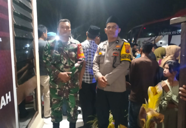 Bhabimkamtibmas Polsek Barumun Polres Palas Aipda Irdan Hasibuan bersama anggota Koramil 10 Binanga J saat melaksanakan PAM kepulangan jamaah haji asal Eks Kecamatan Barumun Tengah. (And/ist)