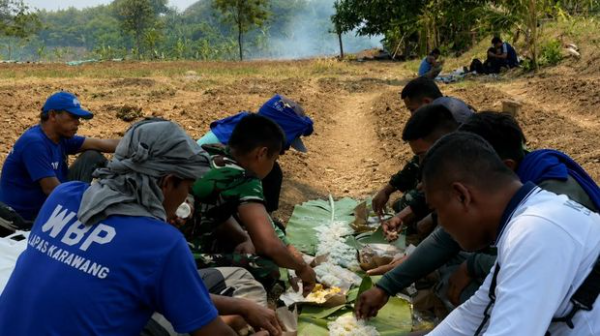 Sebanyak 10 warga binaan Lapas Kelas IIA Karawang bersama prajurit Kodim 0604/Karawang makan bersama saat menggarap lahan aset Kodim untuk penanaman jagung sebagai bagian dari program ketahanan pangan dan pembinaan kemandirian.